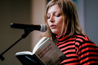 Asta Olivia Nordenhof læser fra 'Penge på lommen' ved prisoverrækkelsesfest på Johan Borups Højskole 23. maj 2022